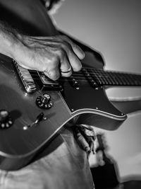 Midsection of man playing guitar