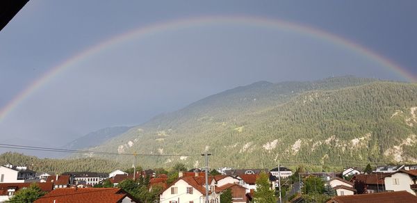 Scenic view of rainbow over town against sky