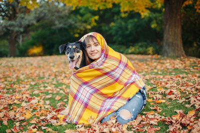 Portrait of woman with dog on street during autumn