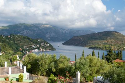 Scenic view of townscape by mountains against sky