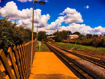 Railroad tracks amidst trees against sky