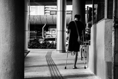 Rear view of people walking on road in city