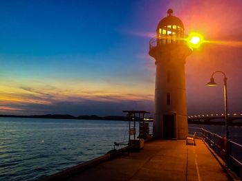 View of illuminated lighthouse at sunset