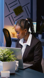 Woman using mobile phone while sitting on table