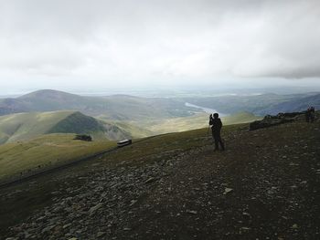 Teenage girl photographing while standing on mountain