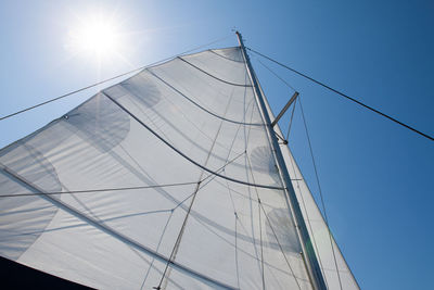 Low angle view of boat canvas against clear blue sky