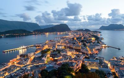 Aerial view of city by sea against sky