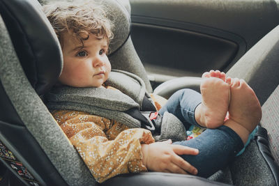 Portrait of cute baby boy sitting in car