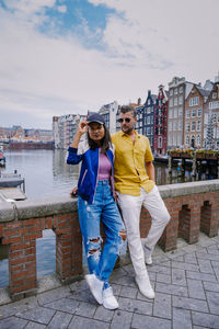 Full length portrait of woman standing against buildings