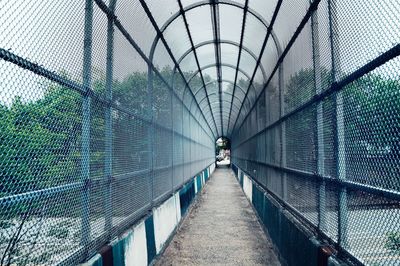 Rear view of woman walking on footbridge