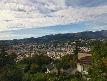 Aerial view of townscape and mountains against sky