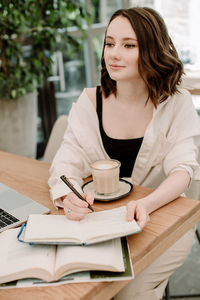 Young woman sitting on table