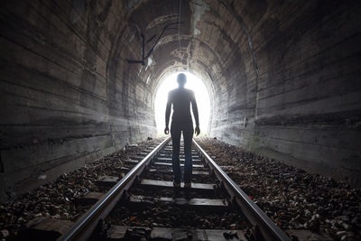 Rear view of silhouette man in tunnel