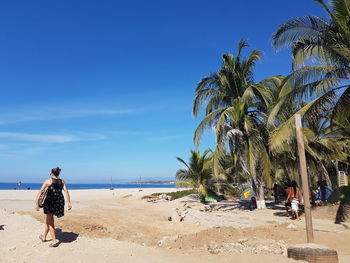 Rear view of people walking on beach