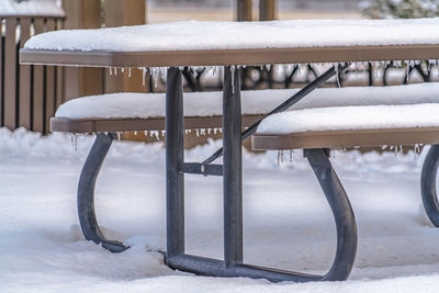 Empty bench on snow covered field