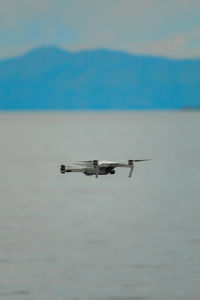 Airplane flying over sea against sky