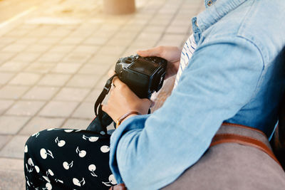 Midsection of man holding camera