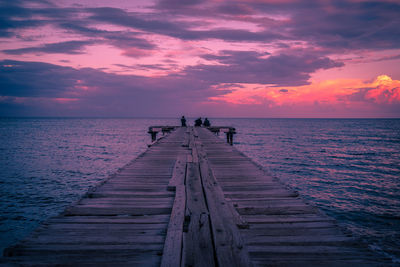 Pier over sea against sky during sunset