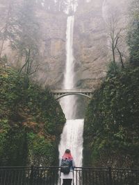 Rear view of woman in waterfall