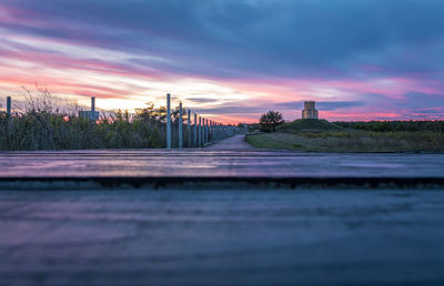 Surface level of river against sky at sunset