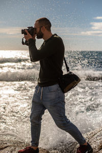 Full length of man photographing sea