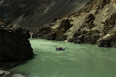 Boat sailing on river by mountain 