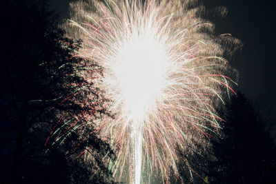 Low angle view of firework display at night