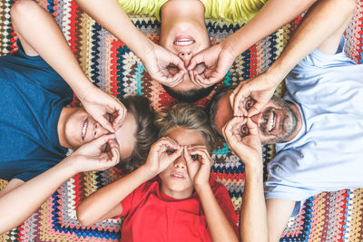 Directly above shot of siblings with father lying on rug