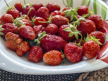 Red ripe strawberries on a plate on the table, macro