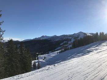 Scenic view of snowcapped mountains against clear blue sky