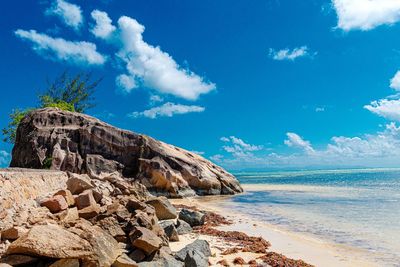 Rock formation on beach against sky