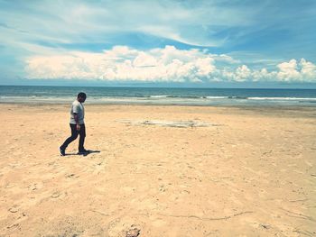 Full length of man on beach against sky