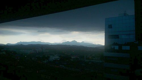 View of cityscape against cloudy sky