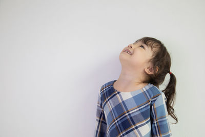 Boy looking away against white background