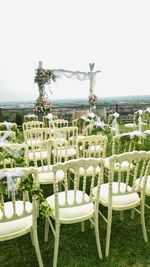 Empty chairs and tables against clear sky