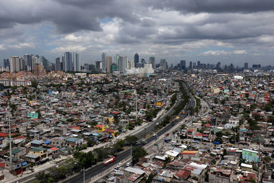 Aerial view of city against cloudy sky