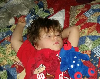 High angle view of boy playing on bed at home