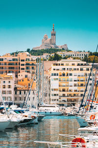 Boats in sea against clear blue sky