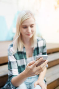 Smiling young woman using mobile phone