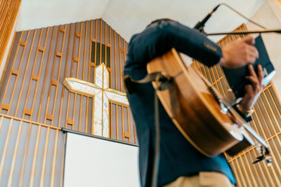 Low angle view of musician playing guitar in church