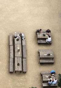 High angle view of people sitting on benches at sidewalk cafe