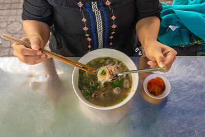 Midsection of woman holding food on table