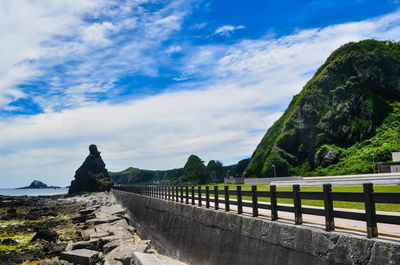 Bridge by mountains against sky