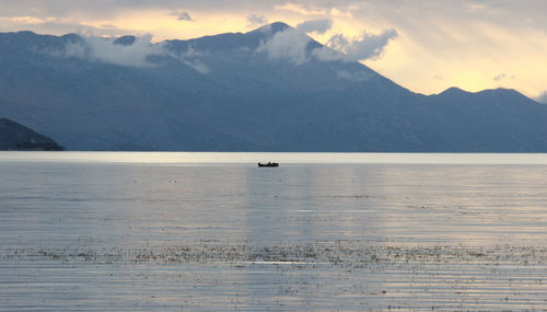 Scenic view of sea and mountains against sky