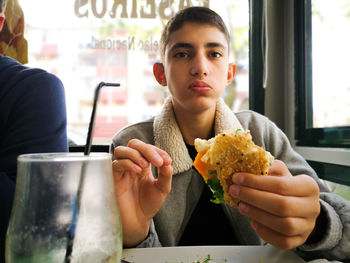 Portrait of men eating food in restaurant