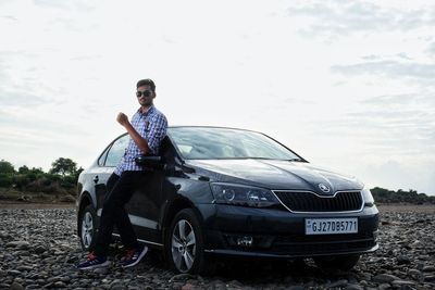 Portrait of man standing by car