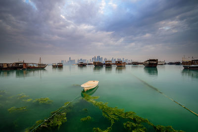 Boats moored in lake against sky