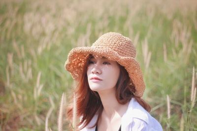 Thoughtful young woman looking away on field