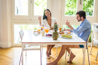 Friends sitting on table at home