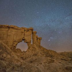 Low angle view of rock formation against sky at night